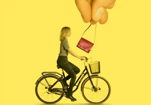 Stor hånd snupper taske fra kvinde på cykel.